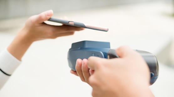 Płatność zbliżeniowa telefonem komórkowym nad terminalem.