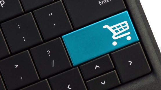 Niebieski klawisz z ikoną koszyka zakupowego na czarnej klawiaturze.