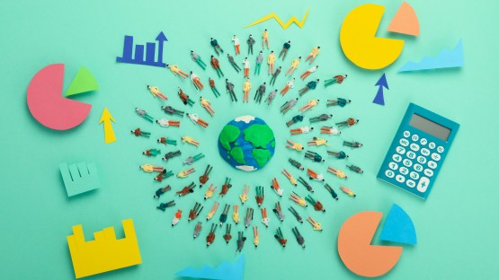 Ludzie wokół globu, kalkulator, wykres kołowy, strzałki wzrostu na zielonym tle.