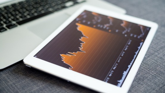 Pomarańczowy wykres przedstawiający 5 sił Portera na białym tablecie.