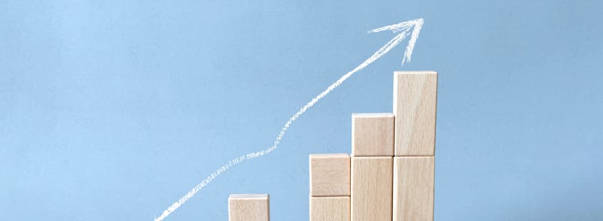 Wykres z drewnianych klocków na niebieskim tle ze strzałką pokazującą czym jest dropshipping a fulfillment.