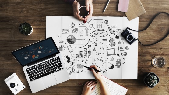 Zespół pracujący nad strategią digital storytelling przy biurku z laptopem.