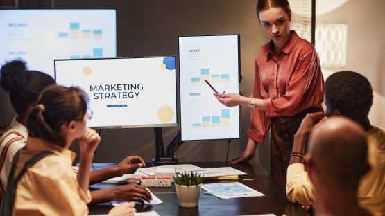 Prezentacja strategii marketingowej dla grupy osób w sali konferencyjnej.