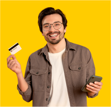 Pan w okularach trzymający w jedej dłoni kartę bankomatową a w drugiej telefon